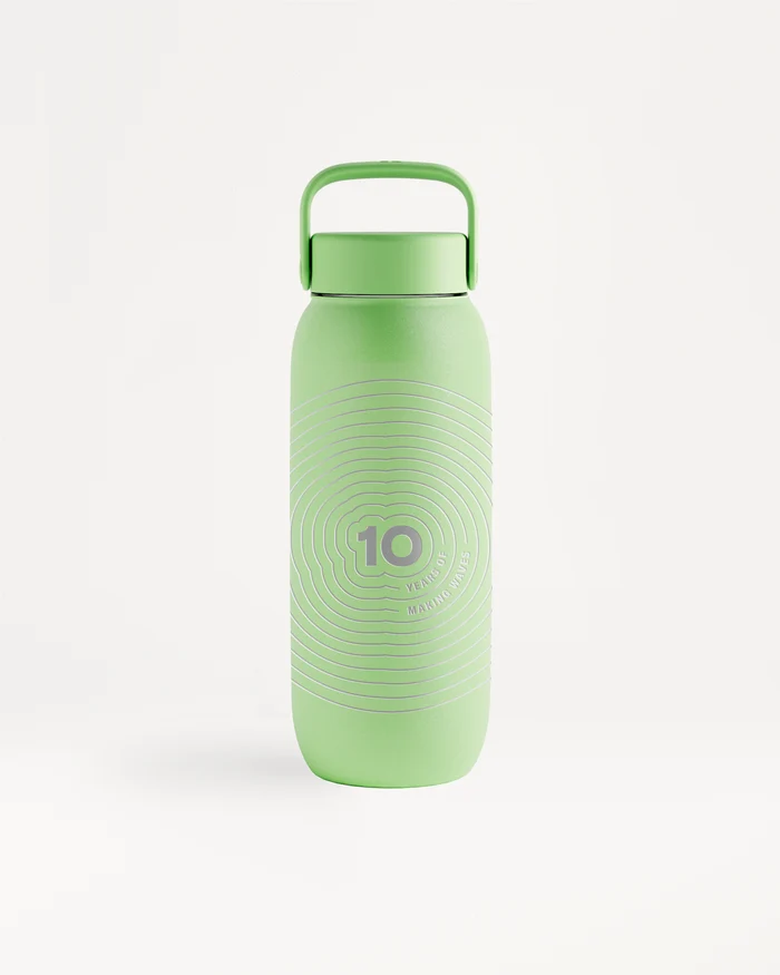 Bouteille d'eau réutilisable vert clair avec poignée supérieure et bouchon à vis, motif circulaire discret.