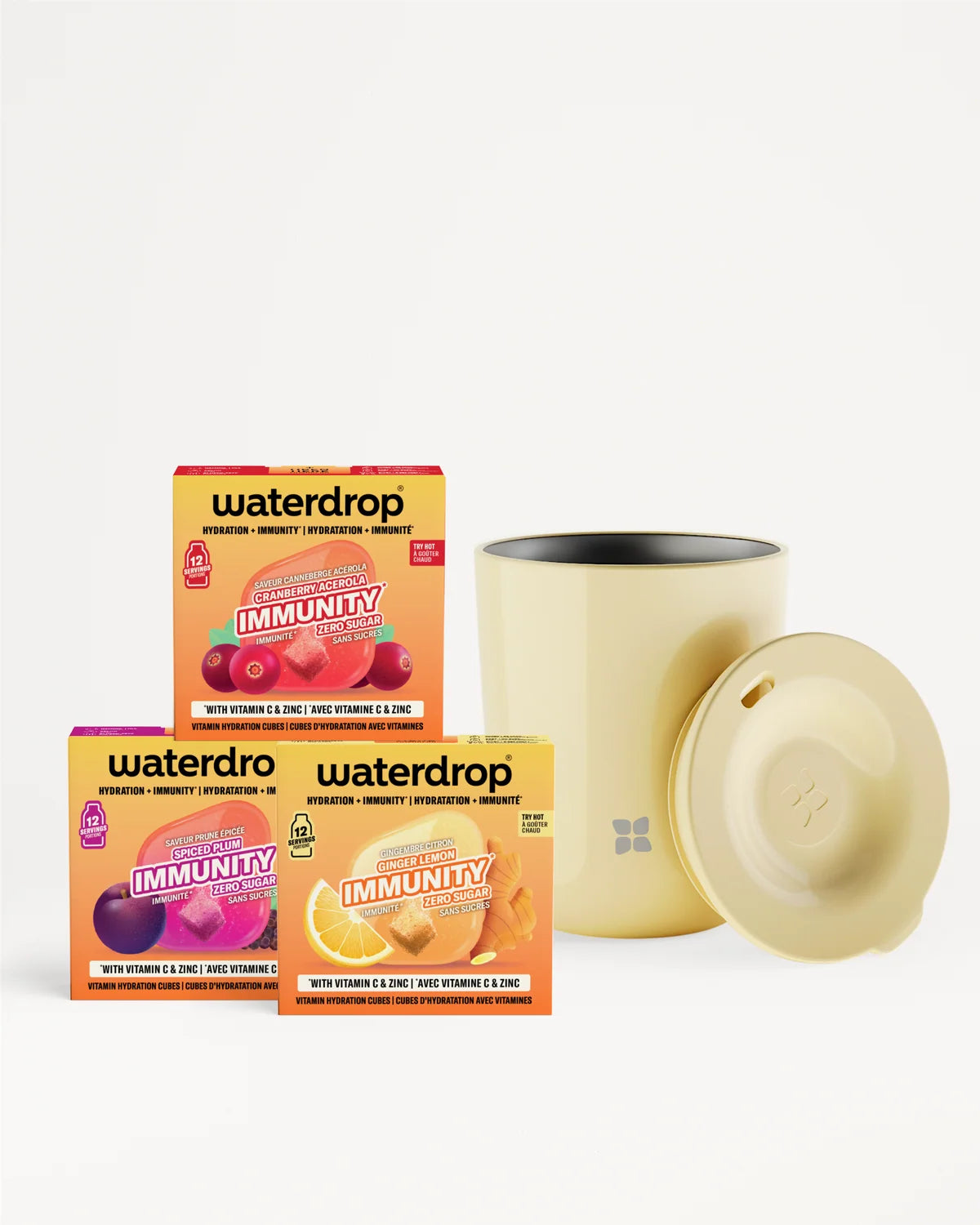 Trois boîtes de mélange vitaminiques et une tasse beige avec couvercle sur fond blanc.