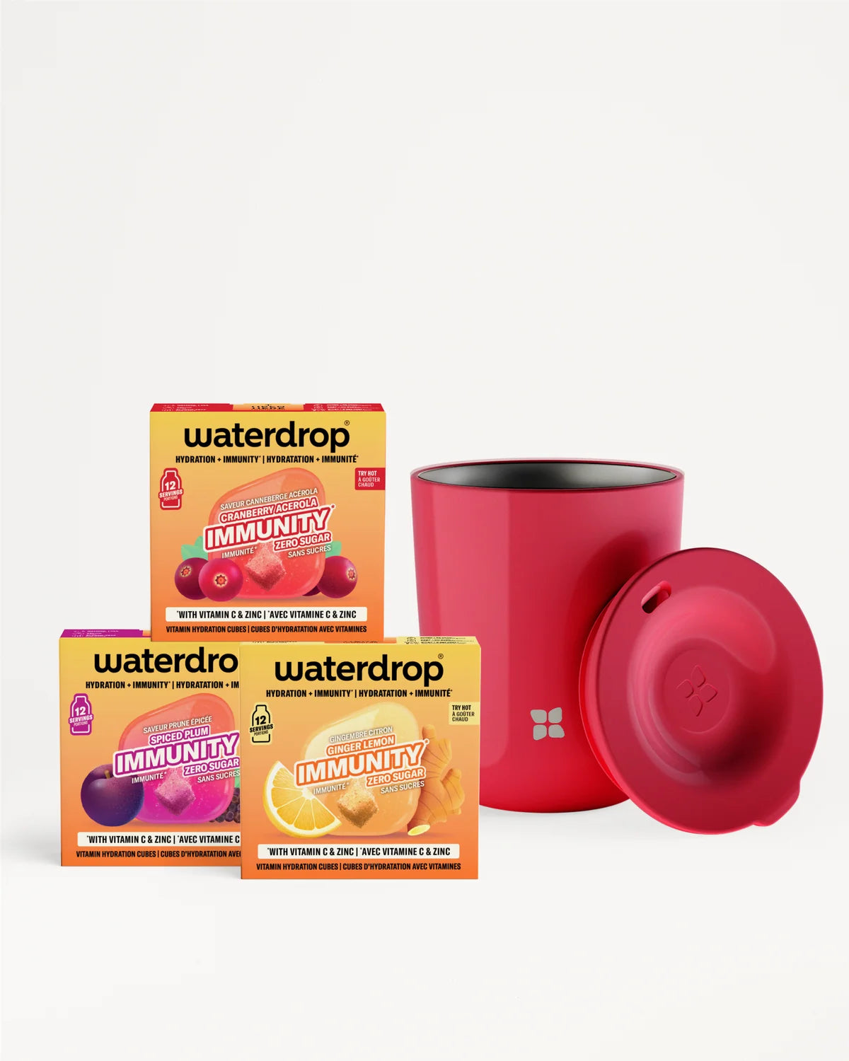 Trois boîtes colorées de sachets de vitamines alignées à côté d'une bouteille rouge cylindrique avec bouchon assorti.