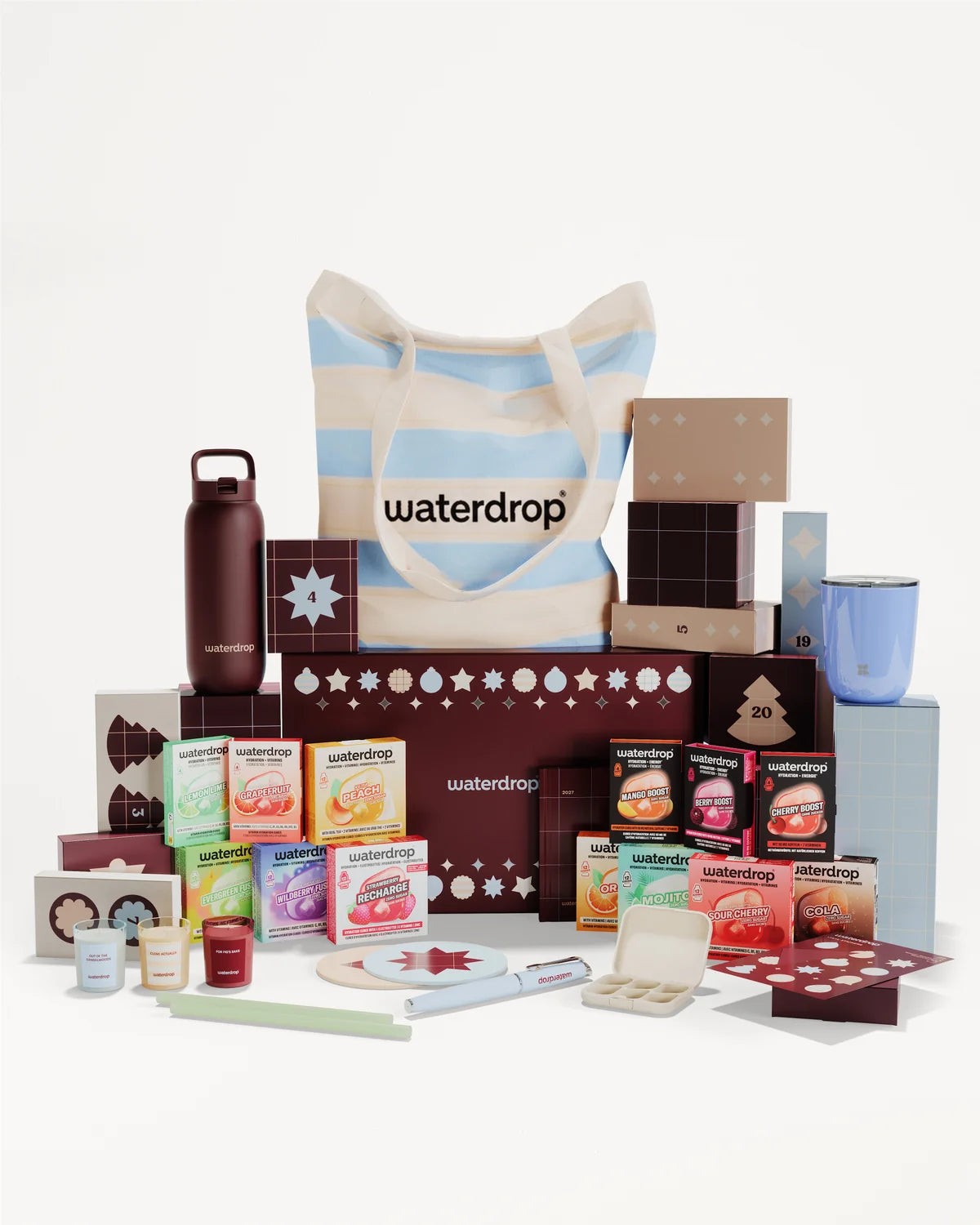 Ensemble cadeau composé de produits emballés et d’articles variés autour d’un sac à rayures.